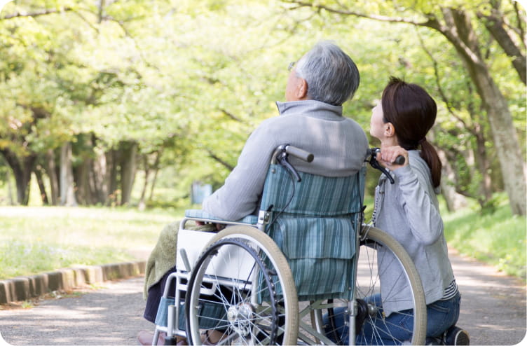 車椅子の利用者の方に寄り添っているスタッフ